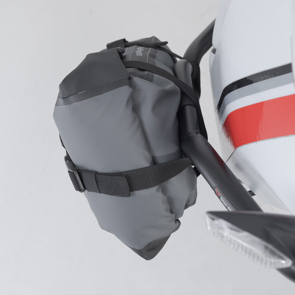 Gray bag attached to a white vehicle with a red stripe.