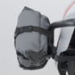 Gray bag attached to a bicycle handlebar against a plain background.